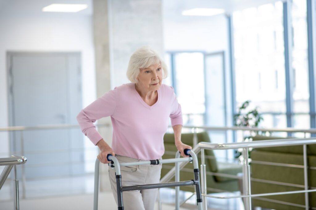 Elderly woman with a rolling walker looking unhappy