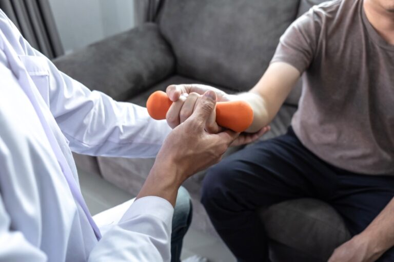 Doctor physiotherapist treating rehabilitation arm pain patient