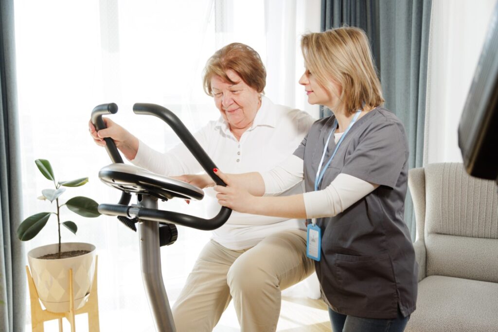 Senior woman doing exercise on bike simulator to keep her health and recovery after trauma