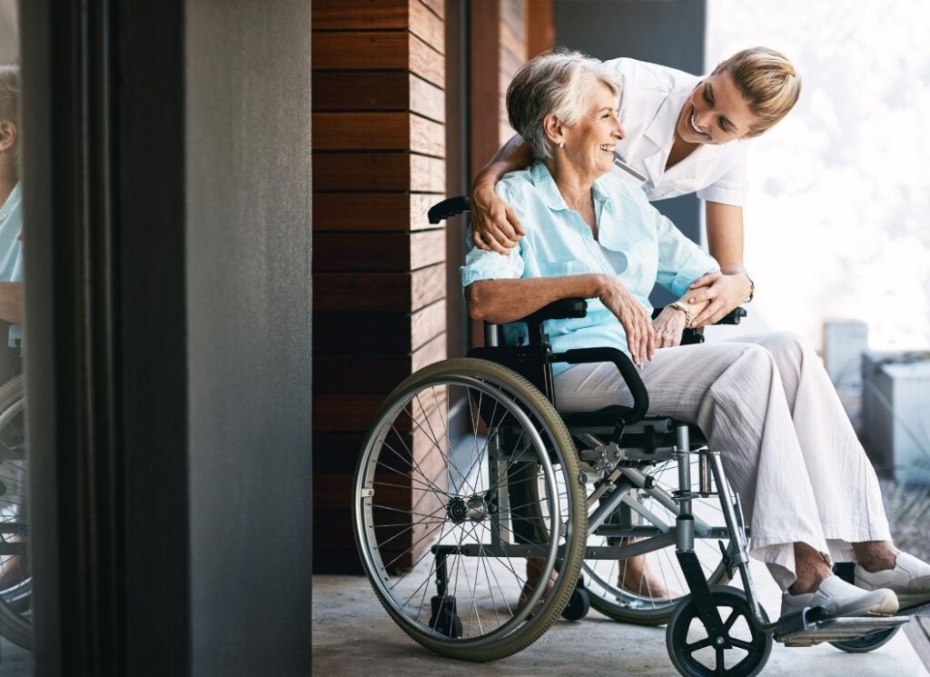 Senior woman nurse outside with wheelchair wellness person with disability healthcare service retirement nursing home support professional caregiver happy people together
